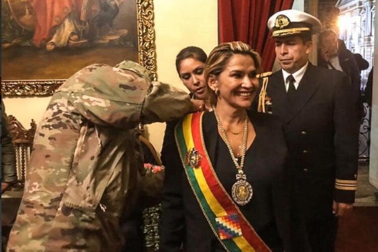 Una militar impone los símbolos presidenciales a Jeanine Áñez, en el Palacio Quemado, en 2019.
