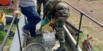 Los policía retiran las bolsas con droga
