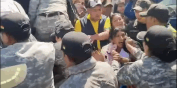 La Policía detiene a una de las manifestantes que atacó la comitiva del presidente.