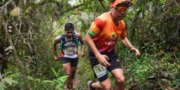 Dos atletas cruzan una zona boscosa en los yungas paceños.