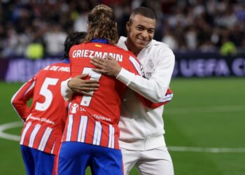 El francés Kylian Mbappe, del Real Madrid, abraza a su compatriota del Atletico de Madrid, Antoine Griezmann, en el partido de ida.