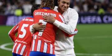 El francés Kylian Mbappe, del Real Madrid, abraza a su compatriota del Atletico de Madrid, Antoine Griezmann, en el partido de ida.