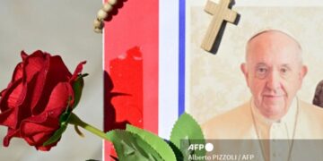 Una imagen del Papa Francisco, una rosa roja y un rosario en la estatua de Juan Pablo II afuera del Hospital Gemelli