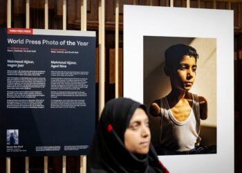 La fotógrafa palestina Samar Abu Elouf posa junto a su foto