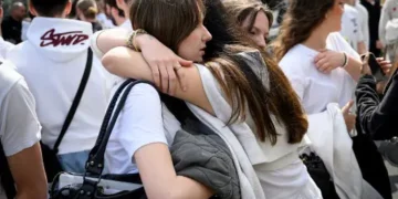 Los compañeros de la fallecida colocaron flores en la puerta de su colegio
