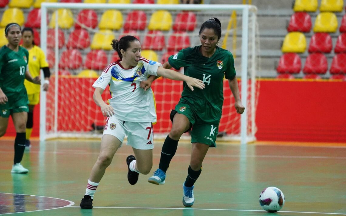 Wendy Baltazar lucha por mantener el balón con la venezolana Zharit Fuentes