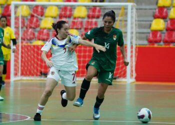 Wendy Baltazar lucha por mantener el balón con la venezolana Zharit Fuentes