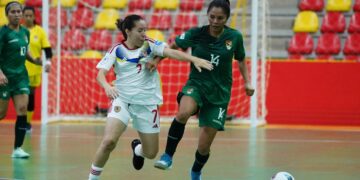 Wendy Baltazar lucha por mantener el balón con la venezolana Zharit Fuentes