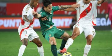 El delantero Carmelo Algarañaz soporta la marca de dos rivales peruanos.