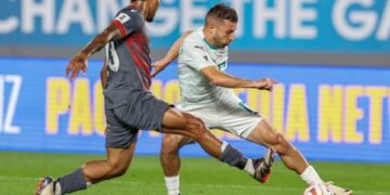 El australiano Kosta Barbarouses presionado por Mickael Partodikromo, de Nueva Caledonia