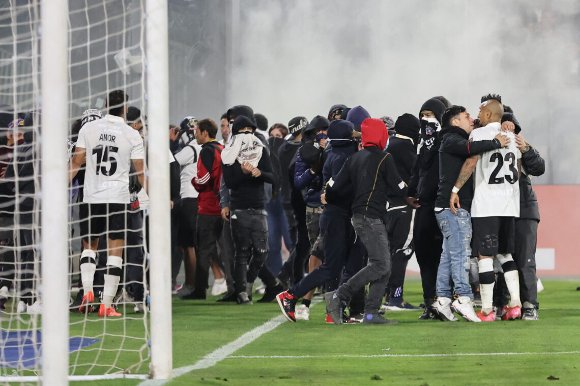 Los hinchas ingresan al campo de juego en el estadio santiaguino