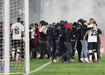 Los hinchas ingresan al campo de juego en el estadio santiaguino