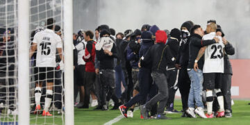 Los hinchas ingresan al campo de juego en el estadio santiaguino
