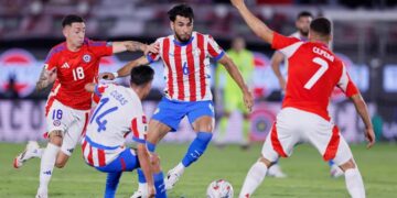 Júnior Alonso control el balón ante la marca del chileno Echeverría
