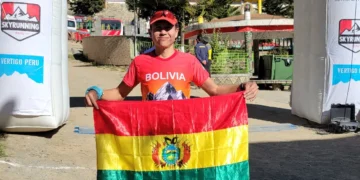 Álvaro Quemaya con la bandera nacional. Crédito: Skyrunning Bolivia
