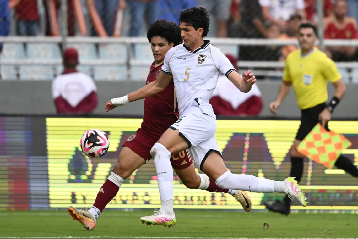 El zaguero boliviano Efraín Morales se anticipa a un rival venezolano.