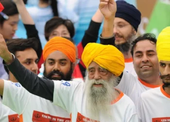 Fauja Singh saluda con un banderín tras finalizar una carrera en Hong Kong. (FOTO: AFP)