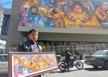 Wilson Zambrana muestra el boceto del mural con la obra final de fondo. Foto: Rubén Atahuichi