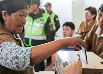 Una persona emite su voto en la primera vuelta electoral con respaldo policial. Foto: Archivo.