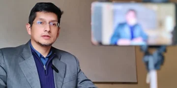 Retrato de un magistrado durante una entrevista grabada en video, en un ambiente institucional con cámara en primer plano.