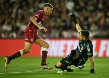 Rodrigo Castillo elude al portero Gabriel Castellón, de la Universidad de Chile, para anotar el gol de la clasificación de Lanús. (FOTO: AFP)
