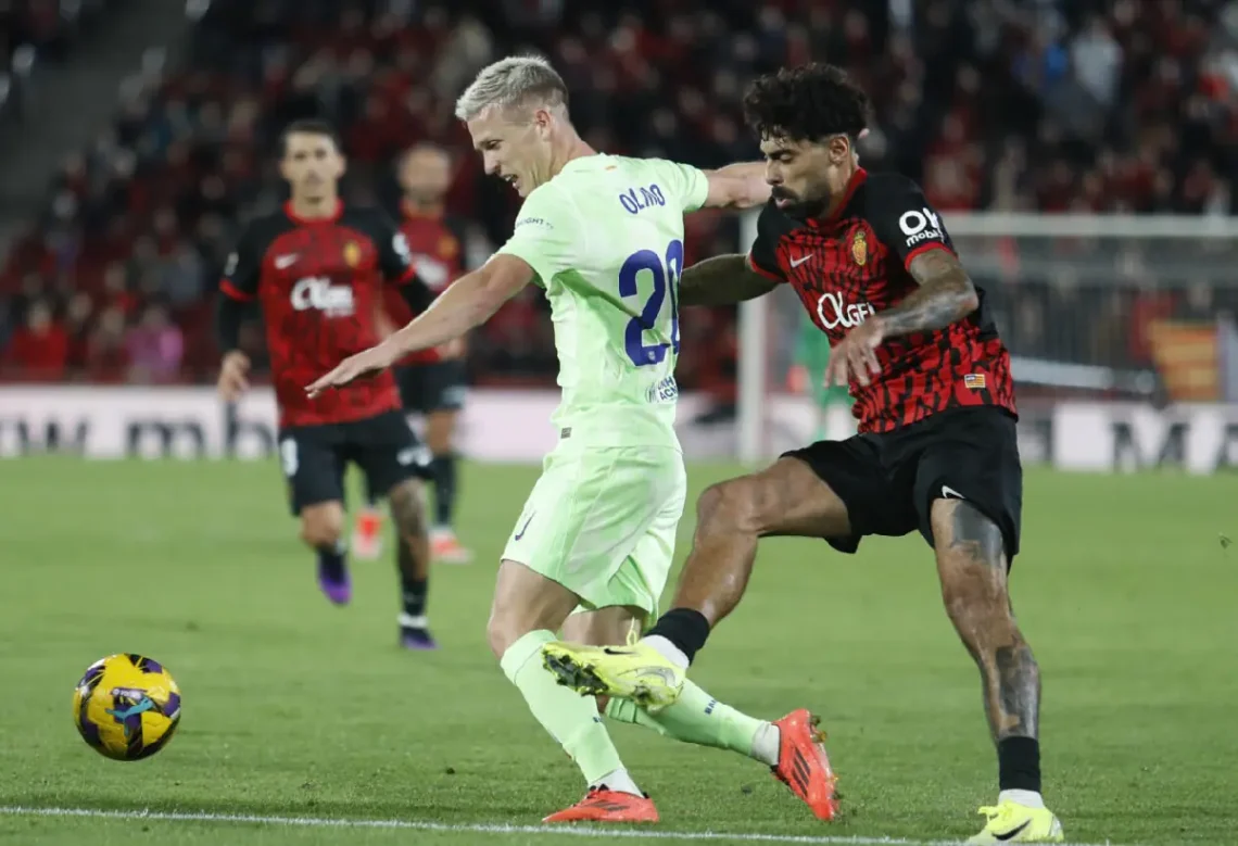 Dani Olmo trata de marcharse de un rival durante el partido liguero entre el Mallorca y el FC Barcelona. (FOTO: AFP)