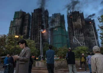La gente observa cómo el humo se eleva del complejo habitacional/AFP