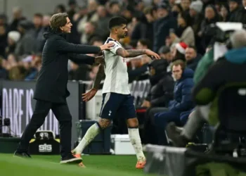 Cristian Romero, del Tottenham, es ayudado a abandonar el campo por su entrenador Thomas Frank. (FOTO: AFP)