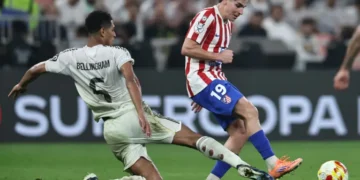 Jude Bellingham trata de cortar el avance del delantero de Atlético Julián Álvarez en la segunda semifinal de la Supercopa de España. (FOTO: AFP)