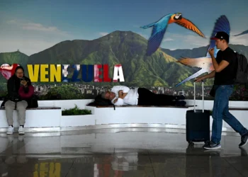 La gente descansa cerca de una puerta de embarque en el Aeropuerto Internacional Simón Bolívar en Maiquetía, estado de La Guaira, Venezuela. Foto: AFP