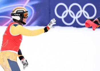 Daniela Maier se prepara para agarrar la bandera de su país tras lograr el oro olímpico en skicross de esquí acrobático. (FOTO: AFP)