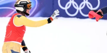 Daniela Maier se prepara para agarrar la bandera de su país tras lograr el oro olímpico en skicross de esquí acrobático. (FOTO: AFP)