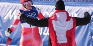 Franjo von Allmen recibe con los brazos abiertos a Tanguy Nef tras el eslalon de éste último en la combinada por equipos de los Juegos Olímpicos de Milán-Cortina. (FOTO: AFP)