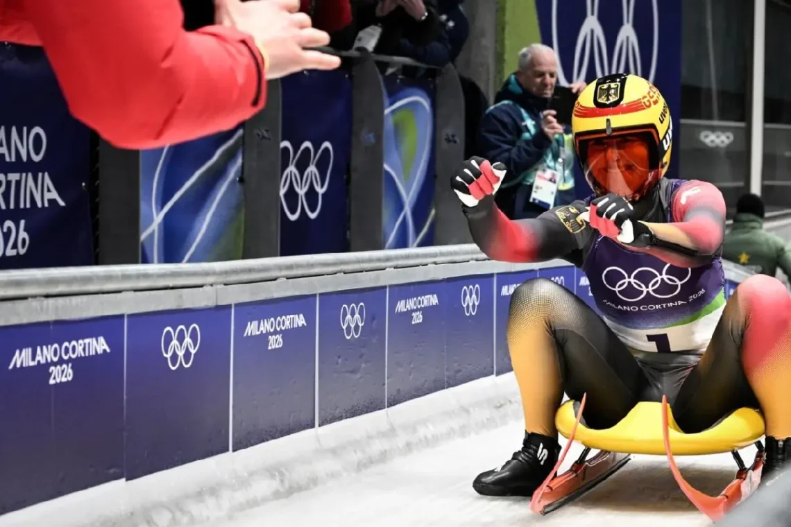 Julia Taubitz festeja con un miembro de su equipo tras terminar su participación en la prueba individual de luge, donde se colgó el oro. (FOTO: AFP)