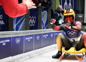 Julia Taubitz festeja con un miembro de su equipo tras terminar su participación en la prueba individual de luge, donde se colgó el oro. (FOTO: AFP)