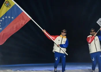 El esquiador de fondo Nicolas Claveau (izquierda) como abanderado de Venezuela en la ceremonia de apertura de los Juegos Olímpicos de Invierno de Milán-Cortina. (FOTO: AFP)