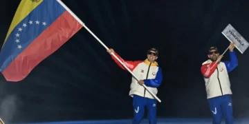 El esquiador de fondo Nicolas Claveau (izquierda) como abanderado de Venezuela en la ceremonia de apertura de los Juegos Olímpicos de Invierno de Milán-Cortina. (FOTO: AFP)