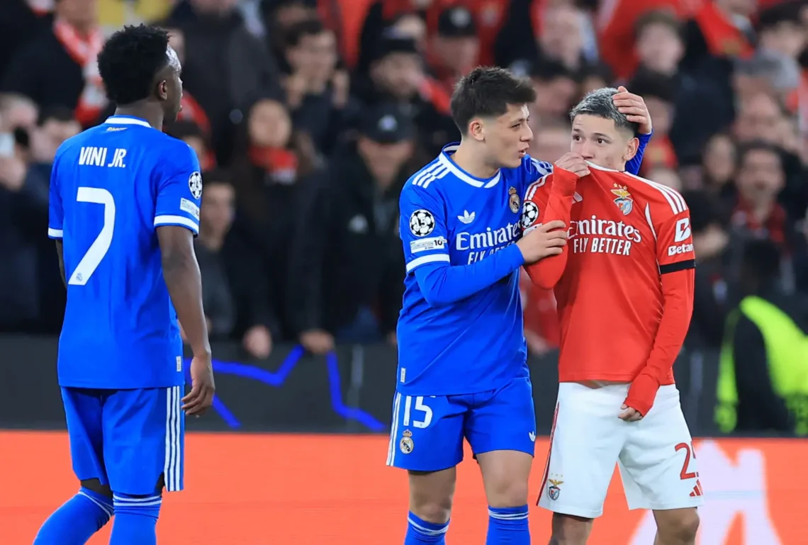 El brasileño Vinicius observa al argentino Prestiani taparse la boca con su casaca y decir algo en el Benfica-Real Madrid por Champions este martes (AFP)