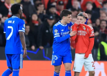El brasileño Vinicius observa al argentino Prestiani taparse la boca con su casaca y decir algo en el Benfica-Real Madrid por Champions este martes (AFP)