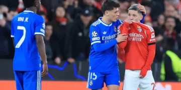 El brasileño Vinicius observa al argentino Prestiani taparse la boca con su casaca y decir algo en el Benfica-Real Madrid por Champions este martes (AFP)