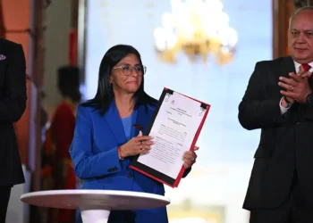 La presidenta interina de Venezuela, Delcy Rodríguez (C), sostiene la ley de amnistía aprobada por la Asamblea Nacional. Foto: AFP
