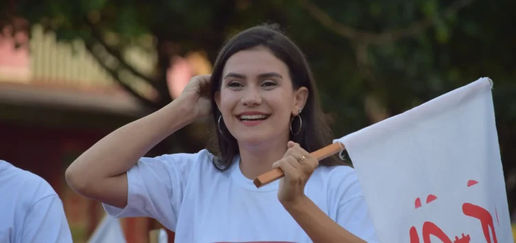 Gabriela de Paiva en campaña electoral en Pando sosteniendo bandera durante actividades rumbo a la Gobernación 2026