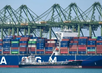 Un petrolero reabastece un buque portacontenedores atracado en la terminal portuaria de Pasir Panjang, Singapur