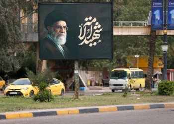 Varios coches pasan junto a una valla publicitaria que muestra al asesinado líder supremo de Irán, el ayatolá Ali Jamenei. Foto: AFP