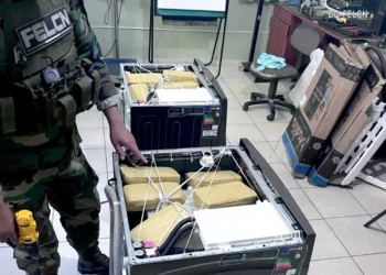 Un agente antinarcótico encuentra la droga escondida en las lavadoras. (Foto: FELCN)
