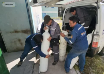 Trabajadores de la UMSA cargan los botellones de oxígeno medicinal. FOTO: UMSA